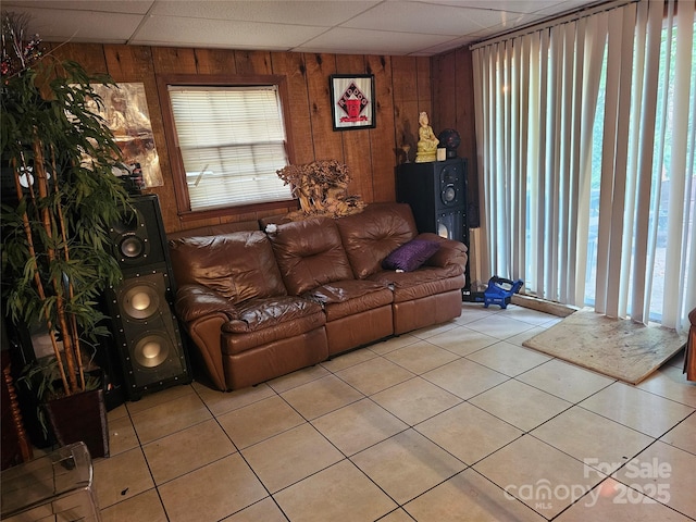 tiled living room with a wealth of natural light and wood walls