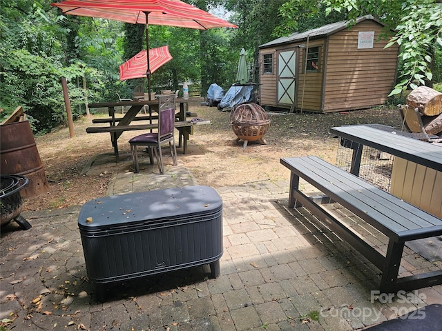 view of patio with a shed and an outdoor fire pit