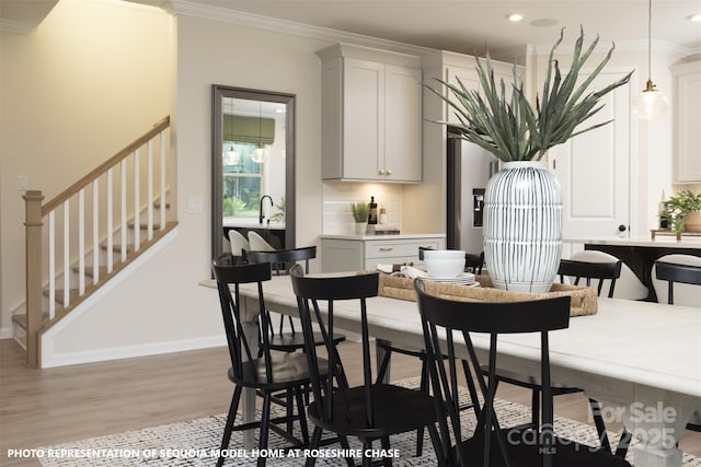 dining space with light wood-type flooring and crown molding