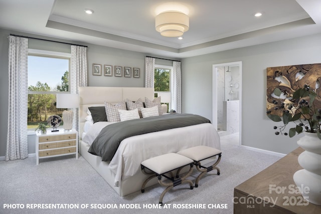 carpeted bedroom with ensuite bath, crown molding, and a tray ceiling