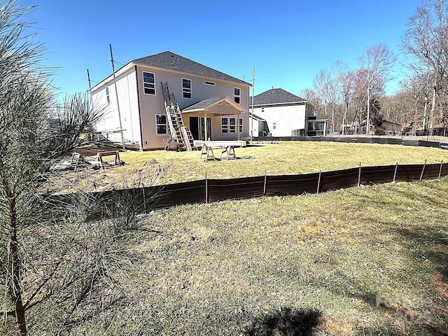 back of property with a yard and fence