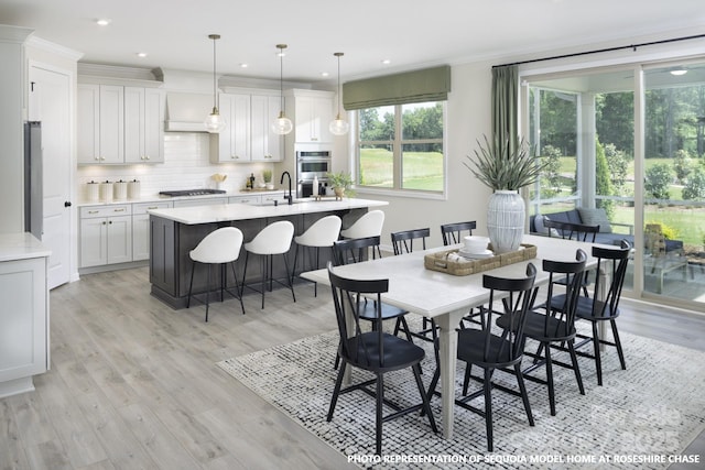 dining area with light wood-style floors, crown molding, and recessed lighting