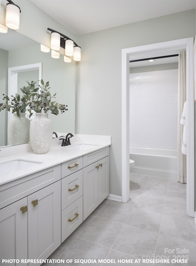 bathroom featuring tile patterned flooring, a sink, toilet, and double vanity