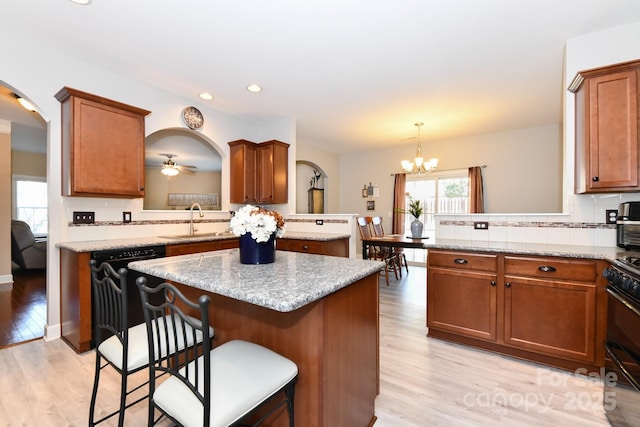 kitchen featuring a breakfast bar area, kitchen peninsula, sink, and pendant lighting