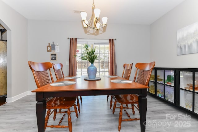 dining space featuring a chandelier and wood-type flooring