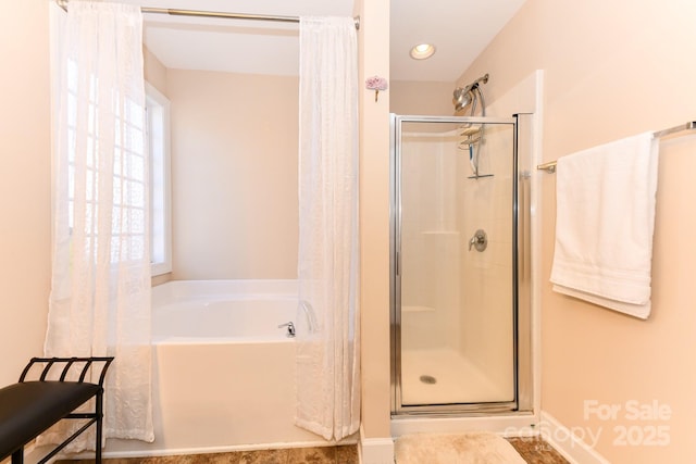 bathroom featuring separate shower and tub