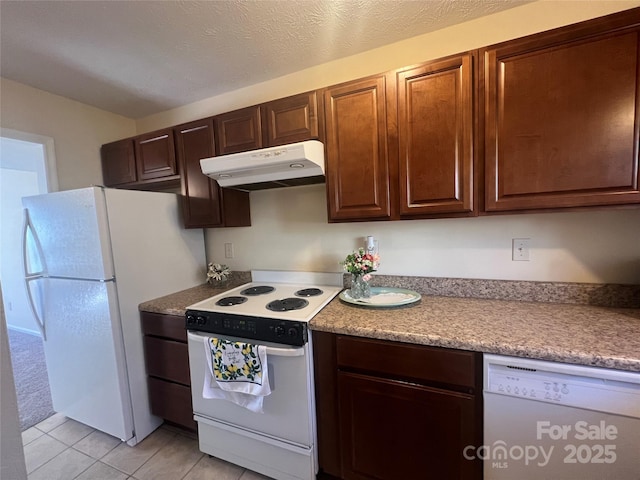 kitchen with white appliances, a textured ceiling, and light tile patterned floors