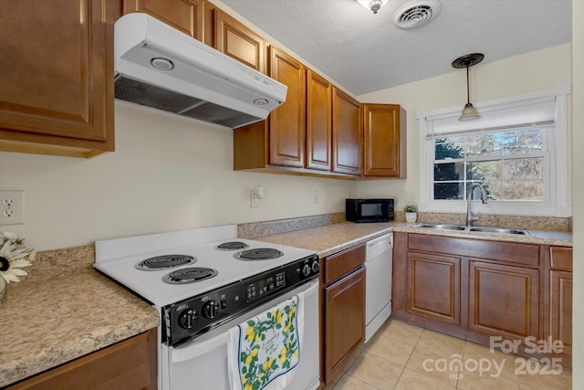 kitchen with sink, white appliances, light tile patterned floors, a textured ceiling, and decorative light fixtures