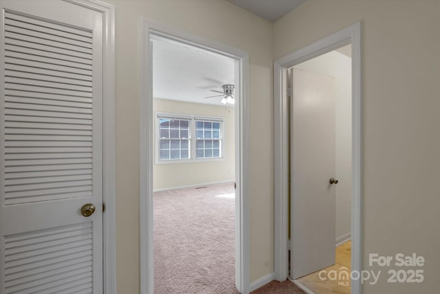 hallway featuring light colored carpet