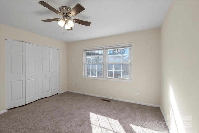 unfurnished bedroom with ceiling fan, a closet, and light carpet