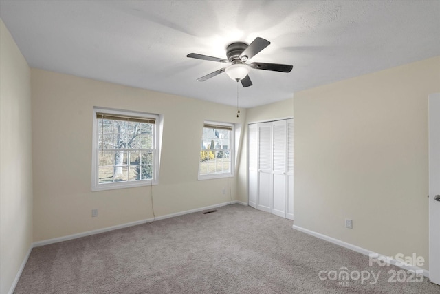 unfurnished bedroom with ceiling fan, a closet, and light carpet