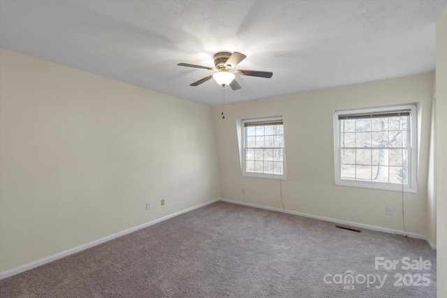 spare room featuring light colored carpet and ceiling fan