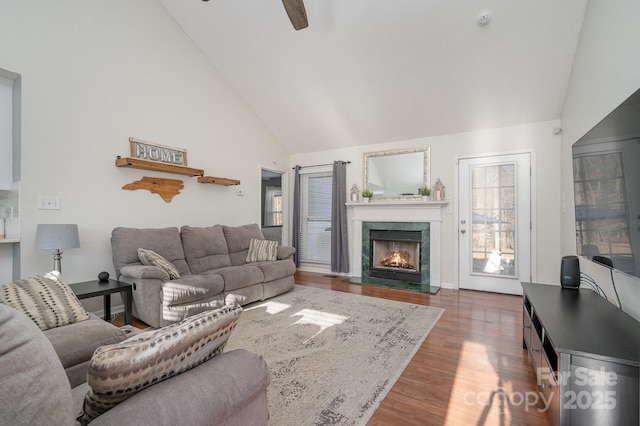 living room featuring a fireplace, dark hardwood / wood-style floors, high vaulted ceiling, and ceiling fan