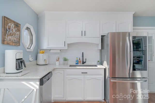 kitchen featuring white cabinets, decorative backsplash, sink, and stainless steel appliances