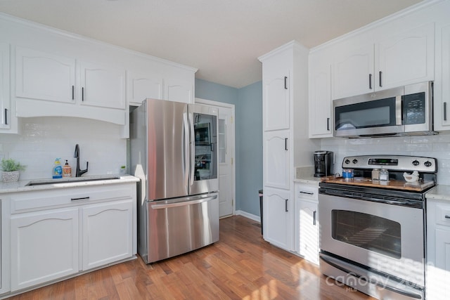 kitchen featuring backsplash, sink, white cabinets, and stainless steel appliances