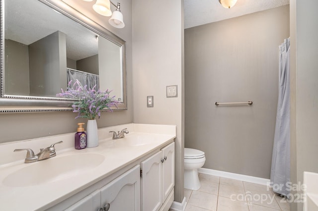 bathroom with tile patterned floors, vanity, a textured ceiling, and toilet