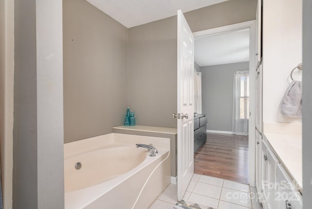 bathroom featuring tile patterned flooring, vanity, a bathing tub, and a textured ceiling