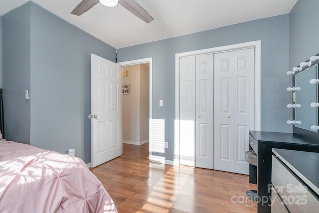 bedroom featuring ceiling fan, a closet, and hardwood / wood-style flooring