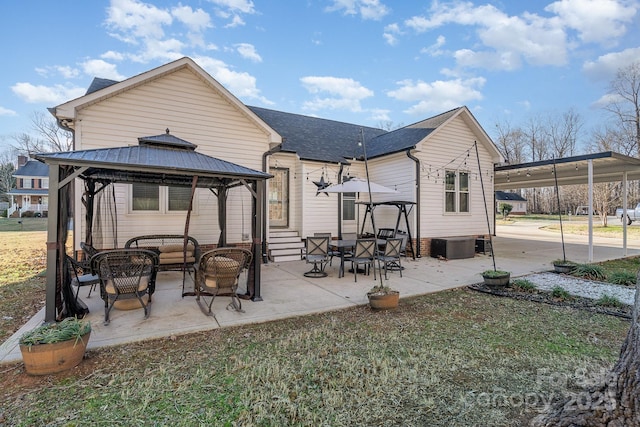 rear view of house featuring a gazebo and a lawn