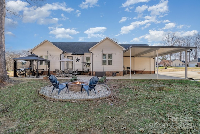 back of house with a patio area, a yard, and an outdoor fire pit