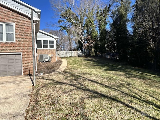 view of yard featuring a garage and central air condition unit