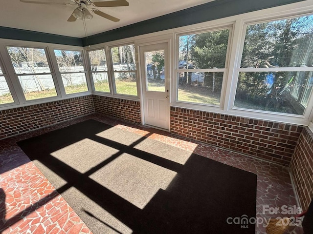 unfurnished sunroom with ceiling fan