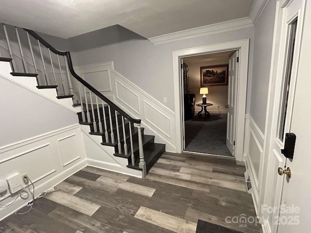 stairs with hardwood / wood-style flooring and crown molding