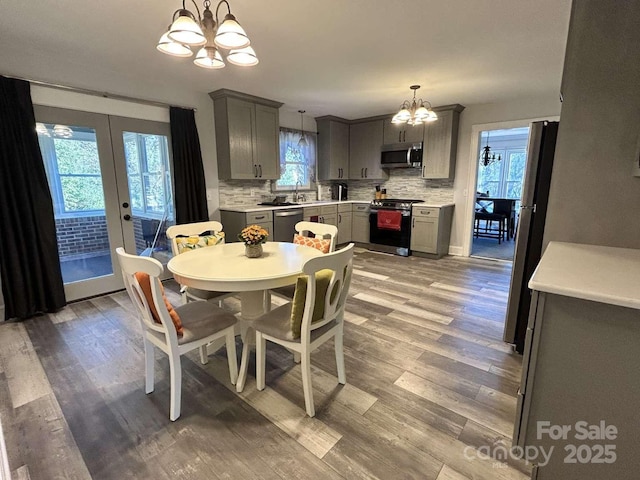 dining space featuring a notable chandelier, light wood-type flooring, and french doors