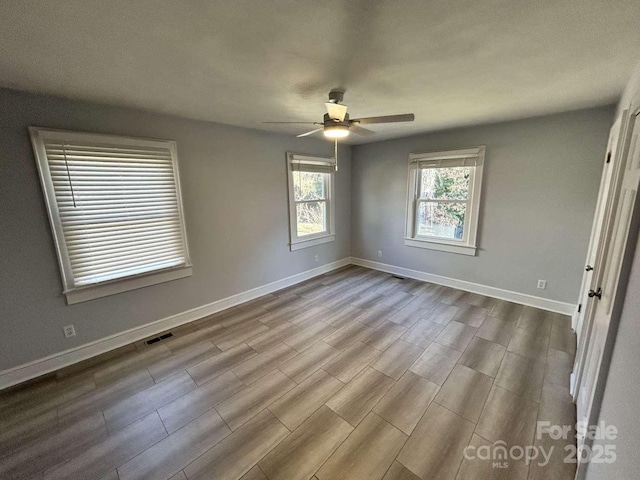 unfurnished room featuring light wood-type flooring and ceiling fan