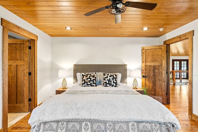 bedroom featuring light hardwood / wood-style floors, ceiling fan, and wood ceiling