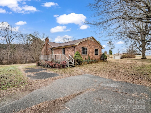 view of front of house featuring an outbuilding, a garage, and a wooden deck