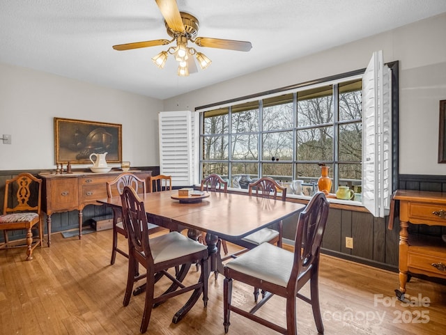 dining space with a textured ceiling, light hardwood / wood-style flooring, and ceiling fan