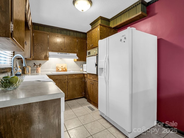 kitchen featuring sink, white appliances, and light tile patterned flooring