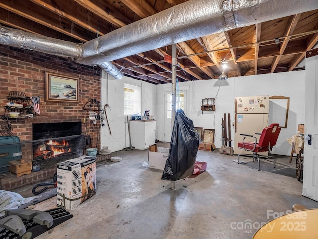 basement with white fridge and a fireplace