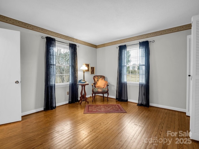 living area with hardwood / wood-style flooring and a healthy amount of sunlight