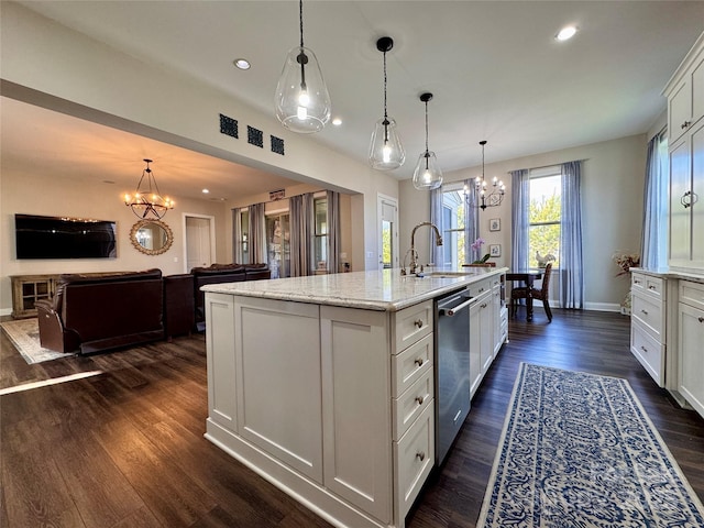 kitchen featuring dishwasher, a center island with sink, sink, light stone countertops, and decorative light fixtures