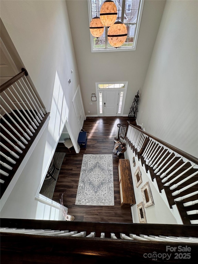 entryway featuring dark hardwood / wood-style flooring and a towering ceiling