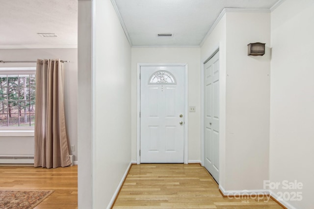 doorway with baseboard heating, crown molding, and light hardwood / wood-style flooring