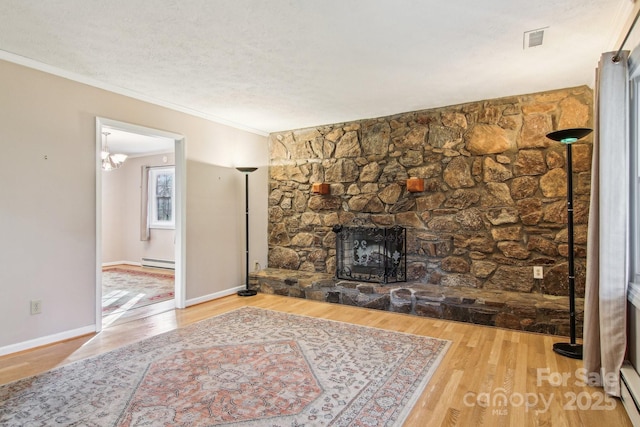 living room with a fireplace, hardwood / wood-style flooring, a baseboard radiator, and crown molding