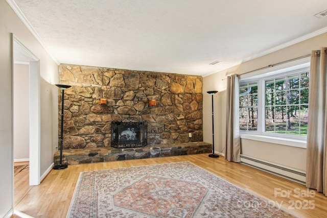 unfurnished living room with a stone fireplace, ornamental molding, wood-type flooring, and a baseboard heating unit