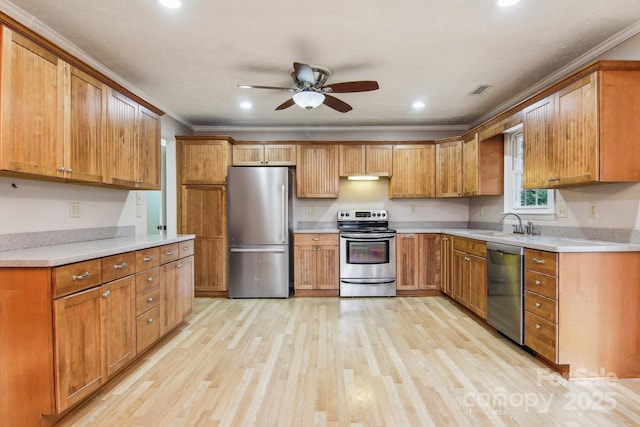 kitchen featuring appliances with stainless steel finishes, light wood-type flooring, ornamental molding, ceiling fan, and sink