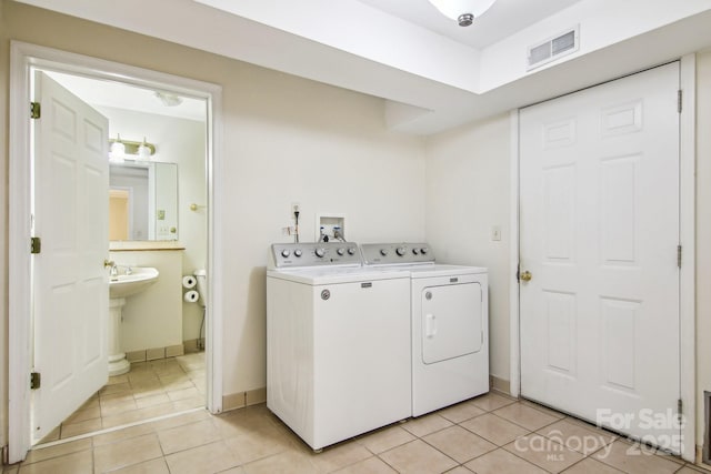 laundry room with light tile patterned floors and washer and clothes dryer