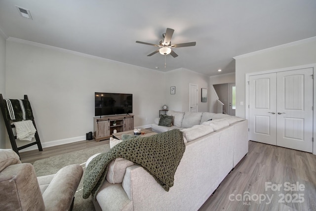 living room featuring hardwood / wood-style floors, ceiling fan, and crown molding