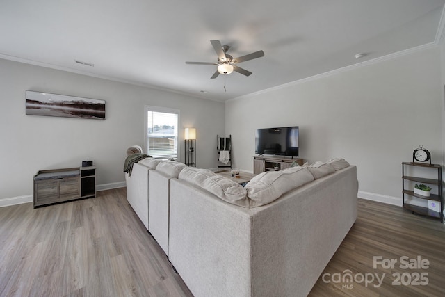 living room featuring hardwood / wood-style floors, ceiling fan, and ornamental molding