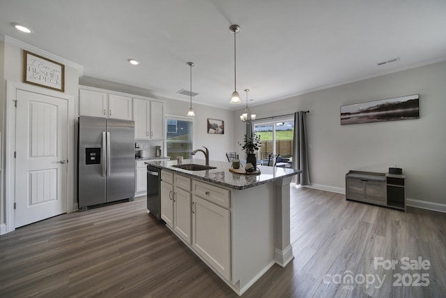 kitchen featuring white cabinets, sink, an island with sink, decorative light fixtures, and stainless steel appliances