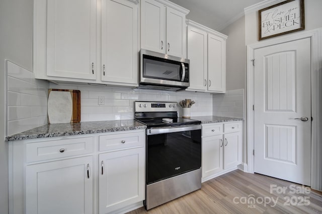 kitchen featuring tasteful backsplash, stainless steel appliances, stone counters, light hardwood / wood-style floors, and white cabinetry