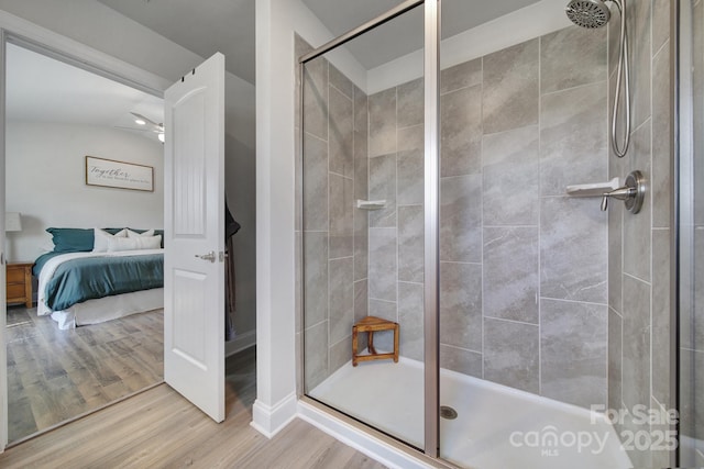 bathroom featuring wood-type flooring, vaulted ceiling, and walk in shower