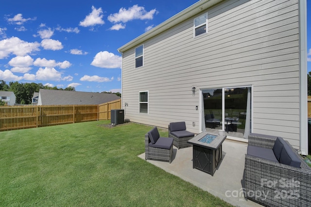 rear view of property featuring a lawn, a patio, central AC unit, and an outdoor fire pit