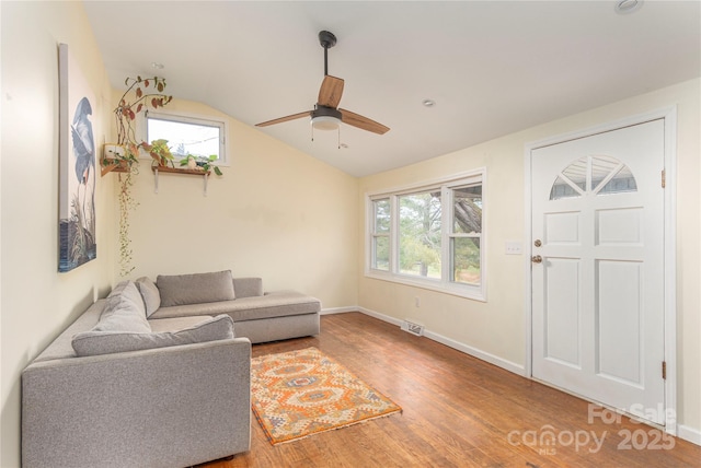 living room with hardwood / wood-style floors, ceiling fan, and vaulted ceiling