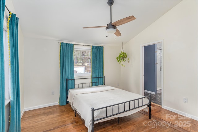 bedroom with hardwood / wood-style floors, ensuite bathroom, ceiling fan, and lofted ceiling